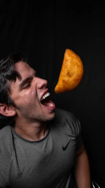 Diner catching a flying empanada in his mouth