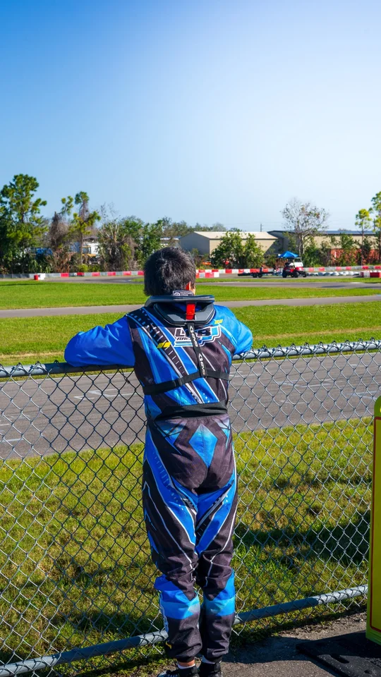 Young driver watching the track from the fence