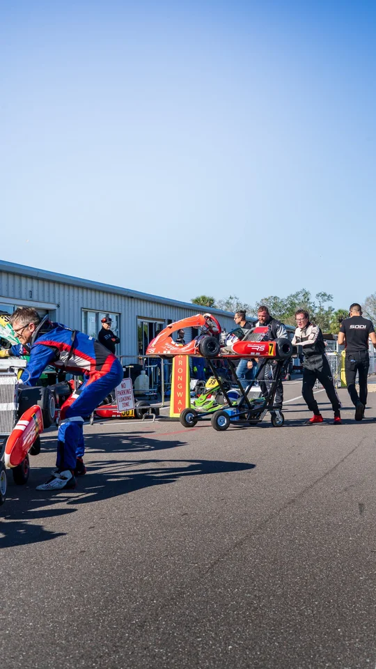 Drivers pushing their karts to the grid